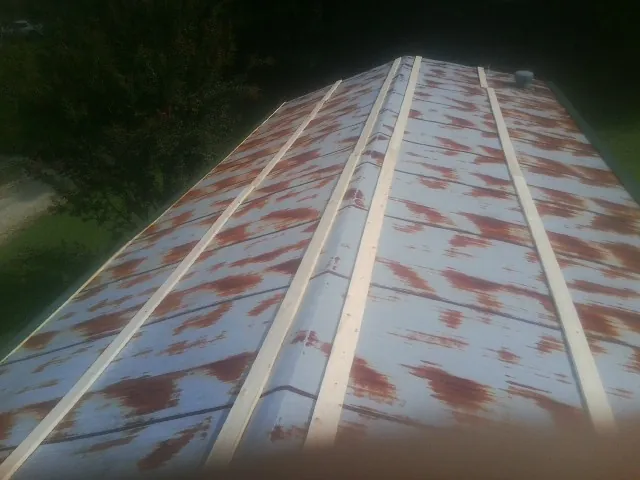 Rusted metal roof panels with new wood purlins before replacement — Storm Damage Roof Repair in Niles by Roofing Brothers