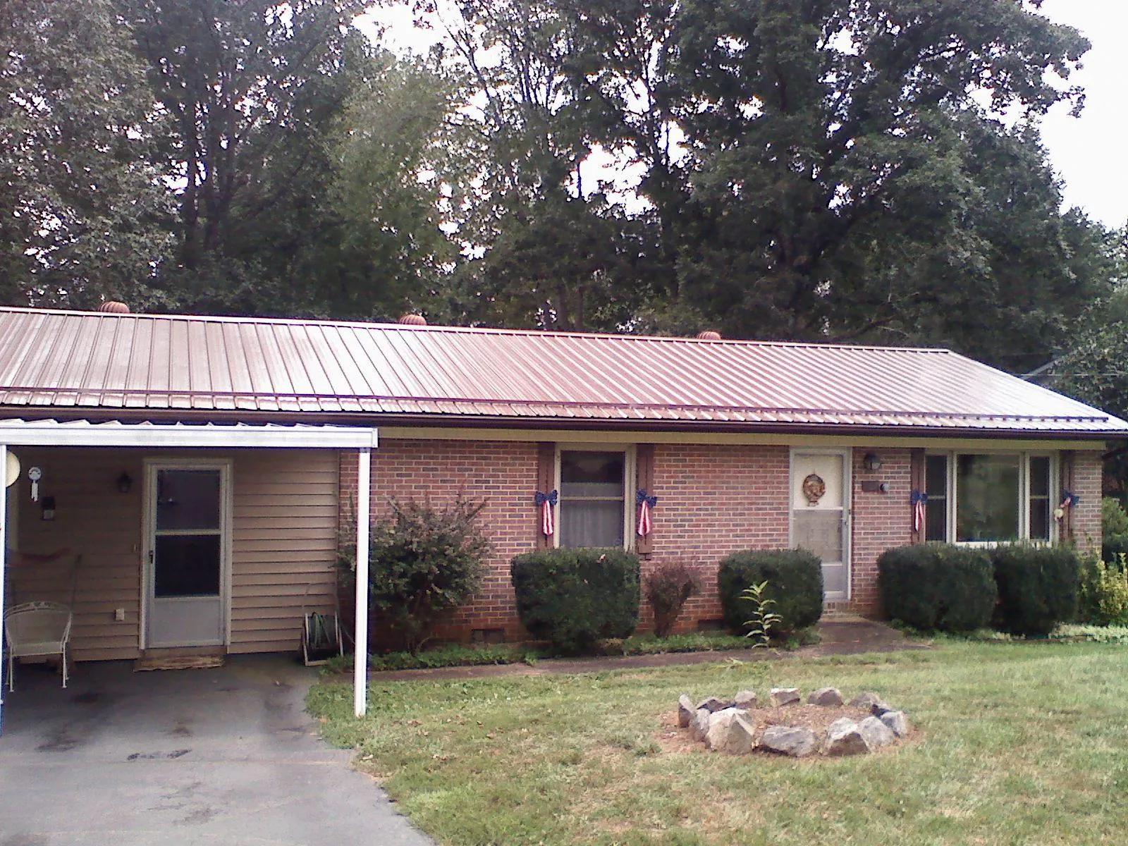 Bronze metal roof and carport on a brick ranch home — Roof Repair work by our crew in Niles