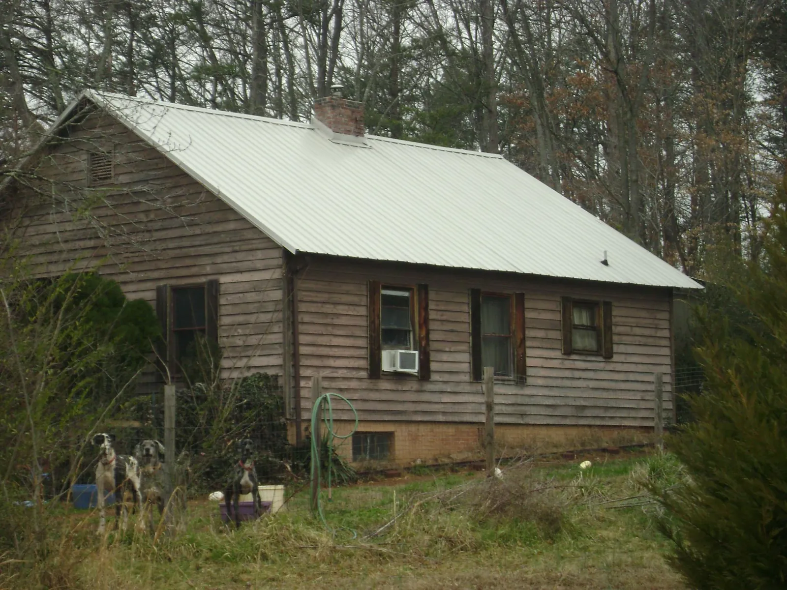 White metal roof on an old wood sided farmhouse, from a Metal Roof Installation job in Niles